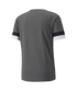 The back view of a gray short-sleeved athletic t-shirt with black and white horizontal bands on the sleeve cuffs, set against a plain white background.